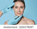 Small photo of Ideal shape of woman face for plastic surgeon, reference female face on blue background. Plastic surgery, concept