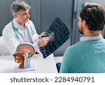 Small photo of Doctor explaining to male patient results of MRI scan of his brain. Diagnosis of diseases and head injuries