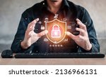 Small photo of Businessman holding shield protect icon. Protection network security computer and safe your data concept, lock symbol, concept about security, cybersecurity and protection against dangers.