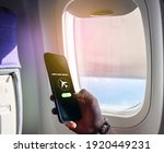 Small photo of Flight mode concept Slide your finger on the screen to turn on Airplane mode, cut off the smartphone communication near the window on the plane. For the safety of the trip