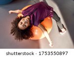 African american teenage girl smiling at camera while working out with exercise ball in gym. Sport, healthy lifestyle, physical education concept. Horizontal shot
