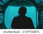 silhouette of a pilot in submarine cockpit under water