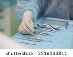 Small photo of Surgical instruments in the operating room. A surgeon preparing for a tooth implantation and sinus lifting operation Dental probe, curettes tweezers, scalpel, needle holder, rasps on instrument table.