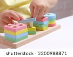 The child plays with colorful toy blocks. eco wooden toys. Little smart child playing natural toys. games for early development. Toy in children's hands close-up