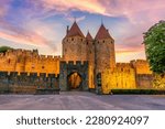 Night view of Carcassone medieval city in France against dramatic sunset sky 