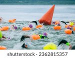 swimmers in open water at the start with a buoy