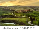 Tuscany, Crete Senesi rural sunset landscape. Countryside farm, cypresses trees, green field, sun light and cloud. Italy, Europe.