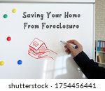 Small photo of Business concept meaning Saving Your Home From Foreclosure with sign on the sheet.