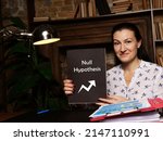 Small photo of Financial concept meaning Null Hypothesis with sign on blank card in hand.