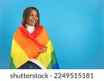 Happy african woman wrapped in a lgbt rainbow flag