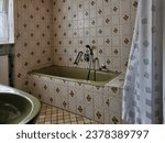Very old bathroom with floral pattern tiles