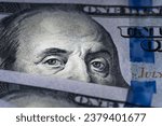 Small photo of Benjamin Franklin's eyes from a hundred-dollar bill. The eyes of Benjamin Franklin on the hundred dollar banknote, backgrounds, close-up. 100 dollar bill with only eyes of Benjamin Franklin
