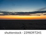 Small photo of Sunset or sunrise on salt lake Elton (Russia) Tall altocumulus and cirrocumulus clouds against the background of salt marsh and a large amount of brine. Evening or morning.