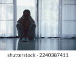 Small photo of Schizophrenia with lonely and sad in mental health depression concept. Depressed woman sitting against floor at home with dark room feeling miserable. Women are depressed, fearful and unhappy.
