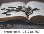 Small photo of One tenth or tithe is basis on which Bible teaches us to donate one tenth of first fruit to God. Coins with Holy Bible. Religion donation and funding. Giving money, the symbol of Christianity donation