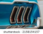 Classic car background. Close-up of the tail light and bumper of classic design, selective background. The concept of restoring old cars. Retro car blue color selective background.