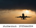 Plane goes on takeoff at sunset. Landing plane at sunset. Cloudy sky