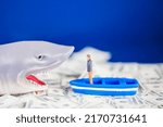 Small photo of Miniature man on a small blue boat facing a loan shark on the dollar ocean. Loan shark concept.