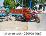Small photo of Three-wheeled boxcar or "Tosa" is parked on the side of the main road. Juwana Pati, Indonesia - May 27, 2023
