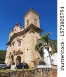 Small photo of Mariana, Minas Gerais, Brazil - September 5, 2018: The exterior of the Saint Peter of the Clergymen Church in Mariana on a sunny day. The historical baroque front facade is stone and the side is white