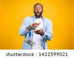 Small photo of Portrait of a happy young afro american man throwing out money banknotes isolated over yellow background.