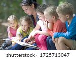 Kindergarten teacher reading with kids in a wood kindergarten