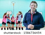 Small photo of Portrait Of Sports Coach With Pupils Standing In Gymnasium