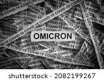 Small photo of Strips of newspaper with the words Omicron and Covid-19 typed on them. Omicron variant of COVID-19. Black and white. Close up.