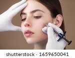 Small photo of Anti-aging face treatment. Close up side on portrait of young pretty woman relaxing on rejuvenation procedure of cheek bone zone by specialist