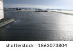 Small photo of Large industrial flat roof with sun evaporating the rainwater from the surface