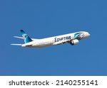 Small photo of London, UK, March 2022 - Egyptian Airline, Egyptair, Boeing 777 captured from slightly above plane level flying from left to right across a clear blue sky