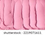 Small photo of Pale pink cosmetic clay powder (alginate modeling facial mask, eye shadow, blush, body wrap) texture close-up, selective focus. Abstract background with brush strokes.