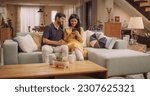 Small photo of Young Indian Couple Using Internet On Smartphone, Sitting On The Sofa at Home, they Tease and Joke around. Playful Boyfriend and Girlfriend Choosing Products, Doing Online Shopping.