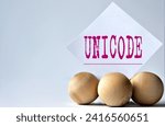 Small photo of UNICODE - word on a white piece of paper on a white background with wooden balls. Info concept