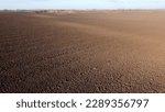 Small photo of Landscape of plowed up land on an agricultural field on a sunny autumn day. Flying over the plowed earth with black soil. Agrarian background. Black soil. Ground earth dirt priming aerial drone view.