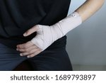 Small photo of Hand injury. Broken wrist and arm with bandage. Hand wrapped in an ace bandage. Using wrist immobiliser after hand injury. Retainer for recovery and release pain in the wrist and hand. Pain at wrist.