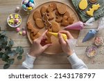 Process of decorating Easter cookies with colored icing. Food holiday concept. Flat lay. Wooden backgrond, top view
