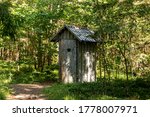 Old wooden toilet in the woods. Outhouse in the wood.