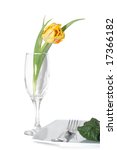 Small photo of Still life of vegetables on a plete and flower in a glass.