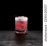 Small photo of Berry sour cocktail on dark concrete background. Classic alcohol cocktail with whiskey and egg foam. Blackcurrant sour beverage in minimal style on black stone background.