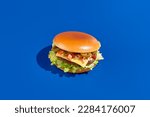 Small photo of Health-conscious alternative meat burger with jalapeno fresh greens on blue. Modern minimalist food photography, horizontal composition. Indulge in eco-friendly, protein-packed, veggie burger.