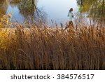 woman running as motion on wooden path beside lake garden at morning light.
