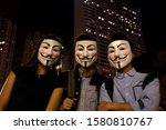 Small photo of Hong Kong - Oct 31, 2019: Three business people don V for Vendetta masks after work for Halloween, protesting the city-wide ban on face masks enacted in October.