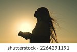 Small photo of girl reads bible book sunset. bible hand. sun book. pray sunset reading bible. man girl ask forgiveness from sun. religious man reads book rays sunlight. travel millennium with book. prayer read.