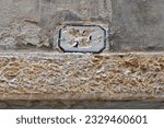 Small photo of Close Up of Old Defaced Number Plaque above Old Stone Doorway
