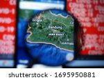 Bandung, West Java/Indonesia on google maps under magnifying glass with Red Covid-19 text Background.                              