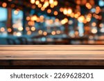Small photo of Empty wooden table in front of blurred cafe bar or restaurant. Abstract lights bokeh background, front view, free space for your product.
