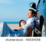 Couple relaxing on car on the beach