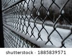 A chain-link fence that is frozen and snowed in