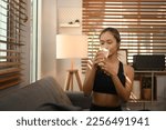 Small photo of Sporty woman drinking collagen supplements after exercise. Natural supplement for skin beauty and bone health